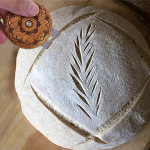 Nahaufnahme eines UFO-Brotmessers aus Palisander beim Schnitzen von Blattmustern