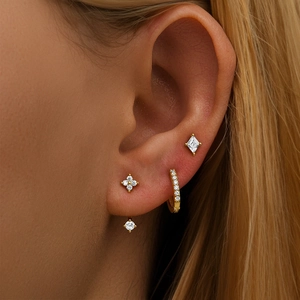 Macro shot of 925 silver star and moon tassel earring set worn on a model's ear