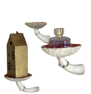 Detailed view of three resin mushroom-shaped wall shelves with red and white textured caps
