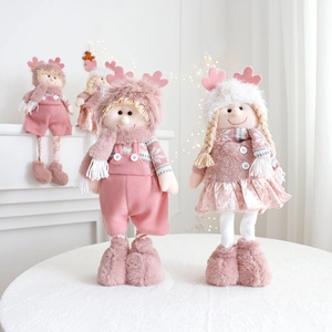 Detail of pink and white plush Christmas dolls with retractable legs in a festive room