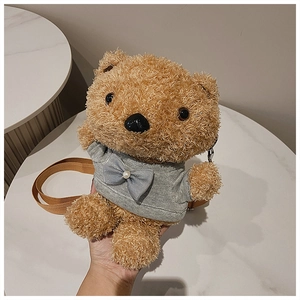 Detail of cute brown teddy bear plush bag with grey t-shirt and pearl bow decoration