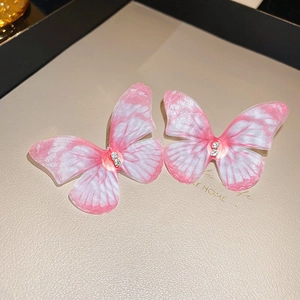 Vue détaillée de boucles d'oreilles papillon avec tulle dégradé rose et cristaux