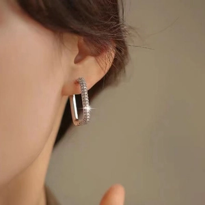 Detail of silver U-shaped hoop earring with micro-pave cubic zirconia on a model