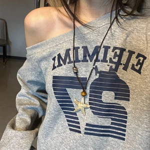 Starfish pendant necklace with wooden beads on grey sweater for beach vacation style