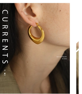 Close-up of model wearing chunky gold water-drop shaped hollow hoop earrings in U-style