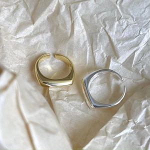 Minimalist irregular geometric open rings in gold and silver finish on textured paper