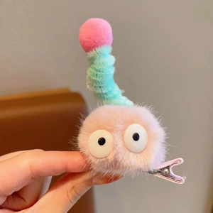 Gros plan d'une barrette à cheveux en peluche rose avec de grands yeux 3D pour les filles