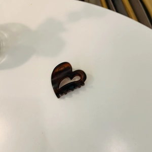 Detail shot of heart-shaped tortoiseshell acetate hair claw clip for side fringes