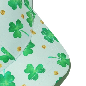 Macro shot of St. Patrick's Day hat featuring green shamrock prints and golden glitter dots