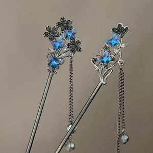 Macro detail of silver hair pins with blue crystal butterflies and flowing tassels