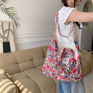 Borsa tote in tela floreale sulla spalla in un ambiente domestico dai dettagli nitidi