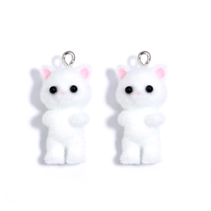 Close-up of white flocked cat charms with pink ears and metal rings for jewelry making