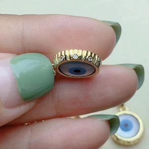 Golden round Evil Eye necklace pendant with rhinestones and blue shell inlay detail