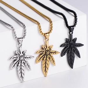 Vue détaillée des pendentifs feuille d'érable en finitions argent, or et noir