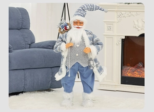 Standing Santa Claus figurine in blue and white knit outfit with lantern by a fireplace