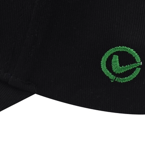 Detailed close-up of green embroidered logo on black cotton baseball cap fabric