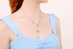Minimalist silver heart-shaped pendant necklace with Y-style design on a model