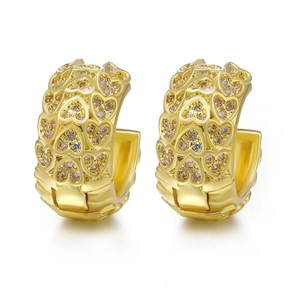 Detailed view of gold C-shaped earrings with heart patterns and cubic zirconia inlays