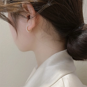 Elegant gold pearl hoop earrings shown worn on ear for a minimalist jewelry look