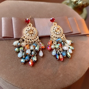 Detail of vintage bohemian earrings with crystal tassels and colorful gemstones