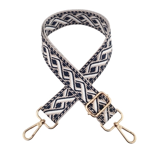 Detail of jacquard embroidered bag strap with geometric pattern and gold metal hardware