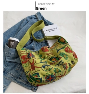 Close-up of green canvas crossbody bag featuring retro prints and wide shoulder strap