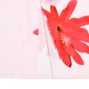 Gros plan sur l'ourlet et l'imprimé floral rouge vif sur le tissu rose d'une robe d'été