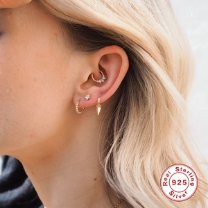 Vue détaillée de piercings d'oreille en argent 925 avec motifs de fleurs et zircon