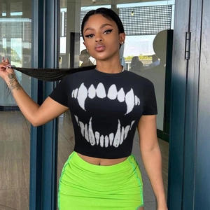 Détail d'un T-shirt noir court avec motif crocs et jupe côtelée de couleur vert fluo