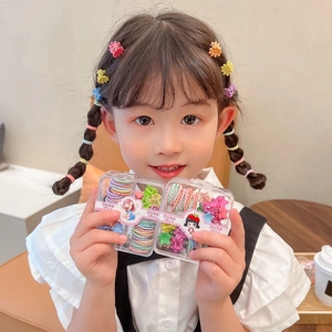 Girl holding two sets of colorful flower hair clips and elastic bands in clear boxes