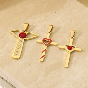 Vue macro détaillée de trois pendentifs croix en or 18 carats avec pierres rouges sur pierre