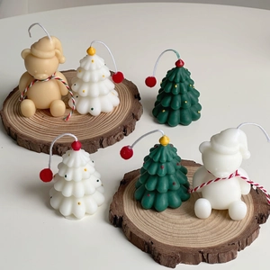 Detail of handmade Christmas tree and bear candles on rustic wood slices for holiday decor