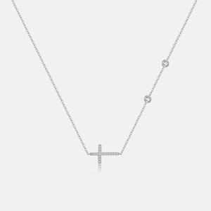 Detail of silver S925 cross necklace with shimmering zircon stones and delicate side charms