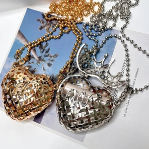 Detail of heart hollow metal clutch bag showing gold and silver woven texture with chain