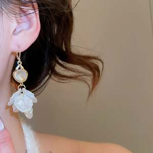 Detail of petal tassel earrings with pearls and opal stones on model for elegant style