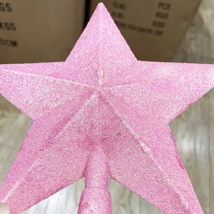 Close-up of pink glitter Christmas tree star topper with sparkling textured surface finish