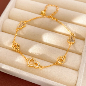 Macro view of 24k gold-plated bracelet with pavé zircon gourd and coin charms