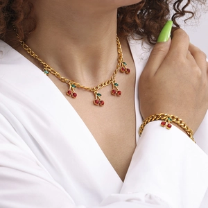 Elegant gold cherry jewelry set featuring red glass stone necklaces and bracelets on model