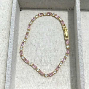 Detail eines Tennisarmband mit rosa Zirkonia-Steinen in einer Goldmetallfassung