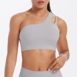 Detail of light grey one-shoulder yoga bra featuring asymmetrical cutout straps