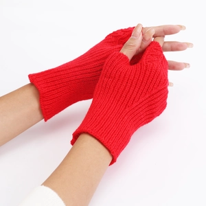 Detail of red knit fingerless gloves showing intricate fish scale pattern and soft texture