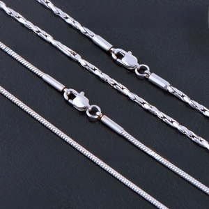 Detailed macro view of silver snake bone chains with lobster clasps and tube end connectors