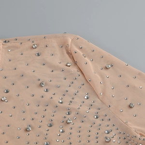Detailed view of nude mesh fabric with hand-applied sparkling silver rhinestones