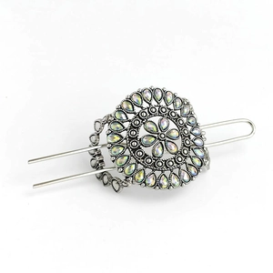Detailed view of silver flower hair stick with iridescent faceted crystals on white