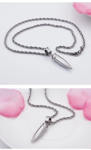 Detail of silver bullet pendant with crystal ring on a stainless steel wheat chain