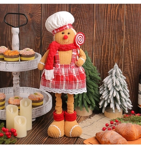 Macro view of gingerbread chef plush decoration with candy cane and red checkered apron