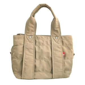 Detail of khaki nylon quilted tote bag featuring wide handles and red side label