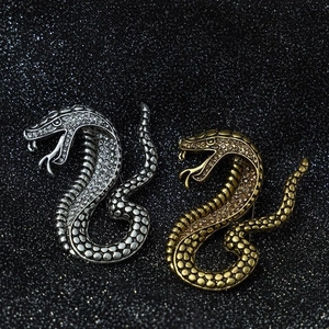 Detailed view of vintage snake brooches in silver and gold plating with crystal rhinestones