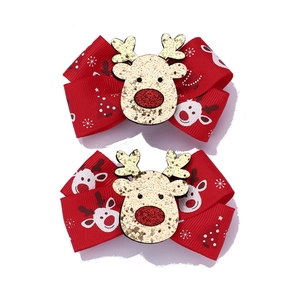 Close-up of handmade Christmas reindeer bow hair clips with glitter accents in red and gold