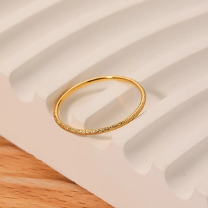 Elegant 18K gold plated frosted stainless steel ring on a white textured display tray